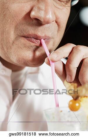 Close-up of a mid adult man drinking pina colada with a drinking straw View Large Photo Image Stock Photo - Close-up of a mid adult man drinking pina colada with a drinking straw. Fotosearch