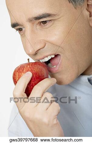 Close-up of a mid adult man eating an apple View Large Photo Image Stock Photo - Close-up of a mid adult man eating an apple. Fotosearch