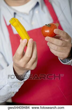 Close-up of a mid adult man holding a tomato View Large Photo Image Picture - Close-up of a mid adult man holding a tomato. Fotosearch
