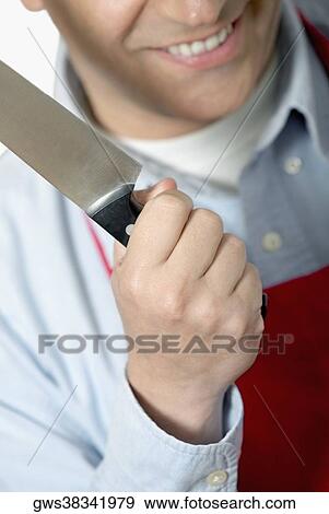 Stock Photo - Close-up of a mid adult man holding a kitchen knife. Fotosearch