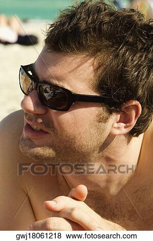 Close-up of a mid adult man lying down with his hands clasped View Large Photo Image Stock Photo - Close-up of a mid adult man lying down with his hands clasped. Fotosearch