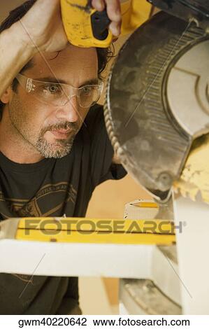 Close-up of a mid adult man operating a circular saw View Large Photo Image Stock Image - Close-up of a mid adult man operating a circular saw. Fotosearch