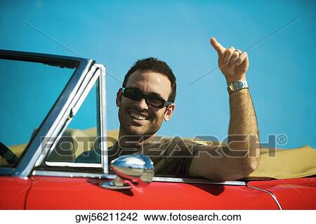 Close-up of a mid adult man sitting in a convertible car pointing forward, Miami, Florida, USA View Large Photo Image Stock Image - Close-up of a mid adult man sitting in a convertible car pointing forward, Miami, Florida, USA. Fotosearch