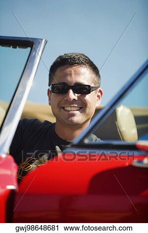 Close-up of a mid adult man sitting in a car View Large Photo Image Stock Image - Close-up of a mid adult man sitting in a car. Fotosearch