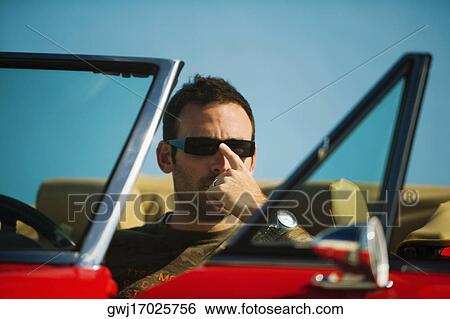 Close-up of a mid adult man sitting in a convertible car, Miami, Florida, USA View Large Photo Image Stock Photograph - Close-up of a mid adult man sitting in a convertible car, Miami, Florida, USA. Fotosearch