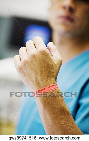 Close-up of a mid adult man's hand with dosage tag around his wrist View Large Photo Image Stock Photograph - Close-up of a mid adult man's hand with dosage tag around his wrist. Fotosearch