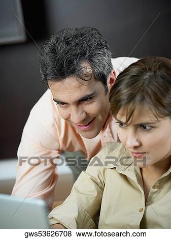 Close-up of a mid adult woman and a mature man using a laptop View Large Photo Image Stock Photo - Close-up of a mid adult woman and a mature man using a laptop. Fotosearch