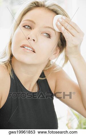 Close-up of a mid adult woman applying powder on her forehead View Large Photo Image Stock Image - Close-up of a mid adult woman applying powder on her forehead. Fotosearch