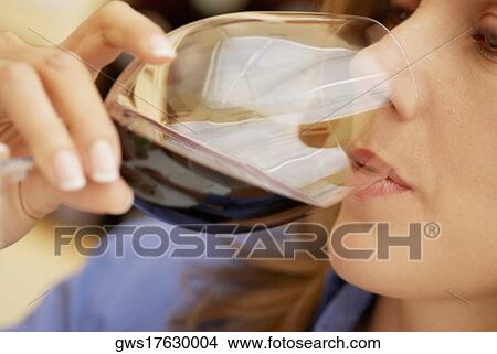 Close-up of a mid adult woman drinking a glass of red wine View Large Photo Image Picture - Close-up of a mid adult woman drinking a glass of red wine. Fotosearch
