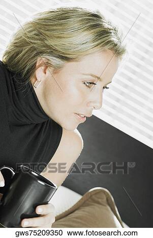 Close-up of a mid adult woman holding a cup of coffee View Large Photo Image Stock Image - Close-up of a mid adult woman holding a cup of coffee. Fotosearch