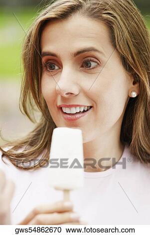 Close-up of a mid adult woman holding an ice-cream View Large Photo Image Stock Image - Close-up of a mid adult woman holding an ice-cream. Fotosearch