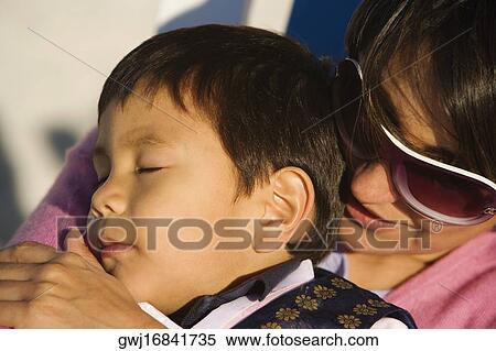Close-up of a mid adult woman hugging her son View Large Photo Image Stock Photography - Close-up of a mid adult woman hugging her son. Fotosearch