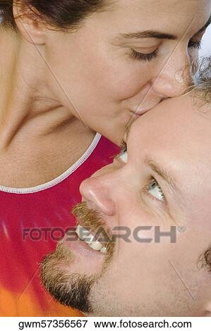 Close-up of a mid adult woman kissing a mid adult man View Large Photo Image Stock Photo - Close-up of a mid adult woman kissing a mid adult man. Fotosearch