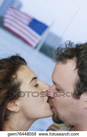Close-up of a mid adult woman kissing a mid adult man View Large Photo Image Stock Photo - Close-up of a mid adult woman kissing a mid adult man. Fotosearch