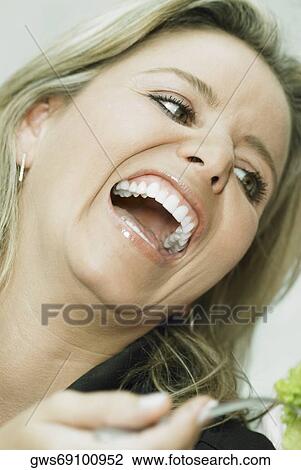 Close-up of a mid adult woman laughing View Large Photo Image Stock Image - Close-up of a mid adult woman laughing. Fotosearch