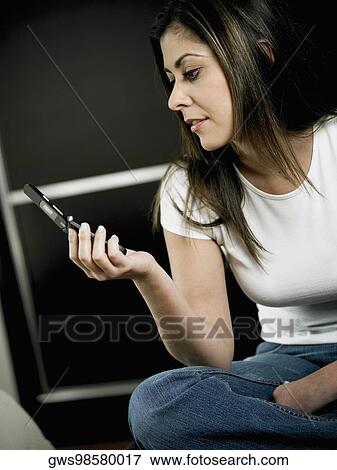 Close-up of a mid adult woman looking at a mobile phone View Large Photo Image Stock Photo - Close-up of a mid adult woman looking at a mobile phone. Fotosearch