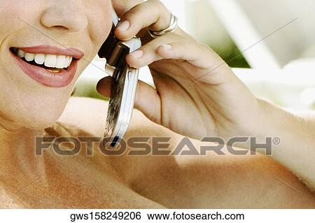 Close-up of a mid adult woman talking on a mobile phone View Large Photo Image Stock Photograph - Close-up of a mid adult woman talking on a mobile phone. Fotosearch