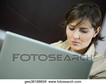Close-up of a mid adult woman using a laptop View Large Photo Image Stock Photo - Close-up of a mid adult woman using a laptop. Fotosearch