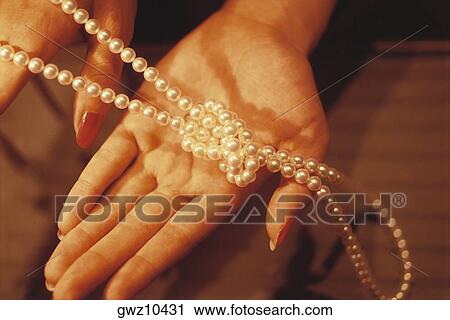 Close-up of a necklace of Mikimoto pearls in a woman's hand View Large Photo Image Stock Image - Close-up of a necklace of Mikimoto pearls in a woman's hand. Fotosearch