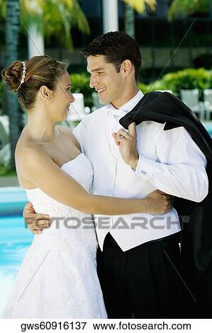 Close-up of a newlywed couple facing each other and smiling View Large Photo Image Stock Photo - Close-up of a newlywed couple facing each other and smiling. Fotosearch