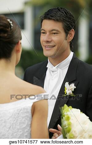 Stock Photo - Close-up of a newlywed couple looking at each other. Fotosearch