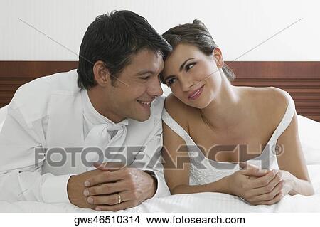 Close-up of a newlywed couple lying on the bed View Large Photo Image Picture - Close-up of a newlywed couple lying on the bed. Fotosearch