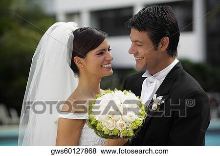 Close-up of a newlywed couple smiling and looking at each other View Large Photo Image Stock Photo - Close-up of a newlywed couple smiling and looking at each other. Fotosearch