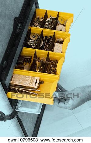 Stock Photo - Close-up of a person pulling a drawer of a tool cabinet. Fotosearch