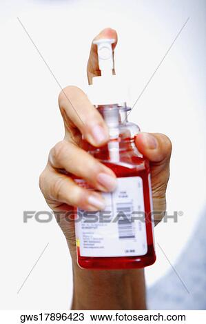 Close-up of a person's hand holding a mouthwash bottle View Large Photo Image Stock Image - Close-up of a person's hand holding a mouthwash bottle. Fotosearch