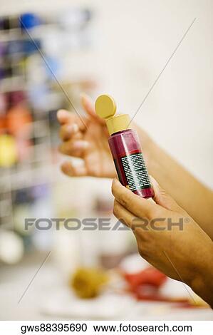 Close-up of a person's hand holding a color bottle View Large Photo Image Stock Image - Close-up of a person's hand holding a color bottle. Fotosearch