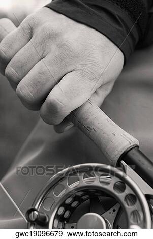 Close-up of a person's hand holding a fishing rod and a fishing reel View Large Photo Image Stock Photo - Close-up of a person's hand holding a fishing rod and a fishing reel. Fotosearch