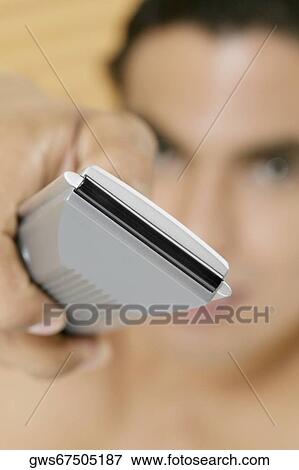Close-up of a person's hand holding a remote control View Large Photo Image Stock Photo - Close-up of a person's hand holding a remote control. Fotosearch