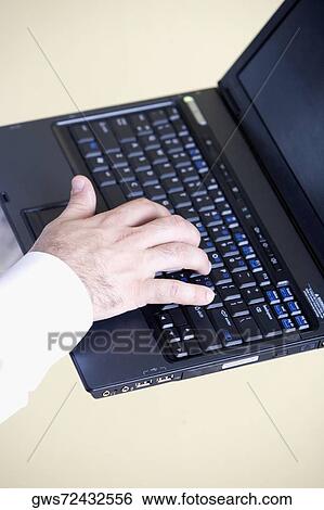 Close-up of a person's hand using a laptop View Large Photo Image Stock Photograph - Close-up of a person's hand using a laptop. Fotosearch