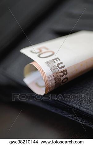 Close-up of a rolled up fifty Euro banknote on a wallet View Large Photo Image Picture - Close-up of a rolled up fifty Euro banknote on a wallet. Fotosearch