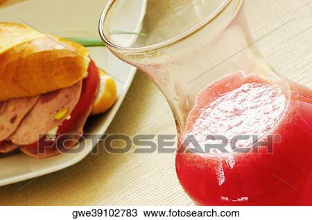 Close-up of a sandwich on a plate with a glass of juice View Large Photo Image Stock Image - Close-up of a sandwich on a plate with a glass of juice. Fotosearch