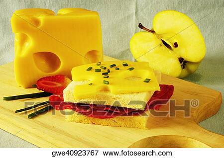 Stock Photo - Close-up of a sandwich with slices of cheese on a cutting board. Fotosearch