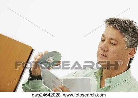 Stock Photo - Close-up of a senior man holding a CD and a CD Case. Fotosearch