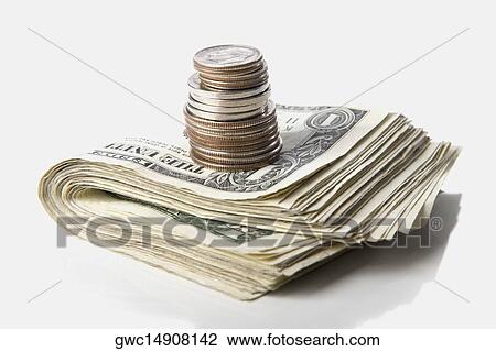 Stock Image - Close-up of a stack of paper currency and coins. Fotosearch