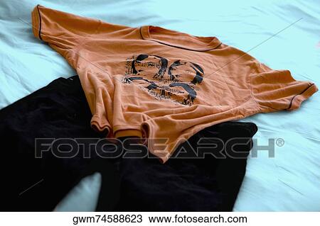 Close-up of a t-shirt and pants on a sheet View Large Photo Image Stock Image - Close-up of a t-shirt and pants on a sheet. Fotosearch