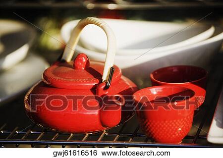 Close-up of a teapot with tea cups and bowls on a rack View Large Photo Image Stock Photograph - Close-up of a teapot with tea cups and bowls on a rack. Fotosearch