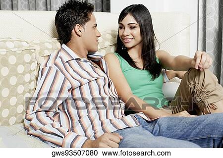Stock Image - Close-up of a teenage girl and a young man sitting on a couch. Fotosearch