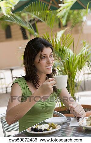 Stock Photograph - Close-up of a teenage girl drinking tea at a restaurant. Fotosearch