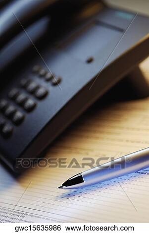 Close-up of a telephone and a pen on a form View Large Photo Image Stock Photograph - Close-up of a telephone and a pen on a form. Fotosearch