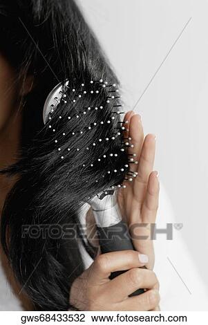 Close-up of a woman brushing her hair View Large Photo Image Stock Image - Close-up of a woman brushing her hair. Fotosearch