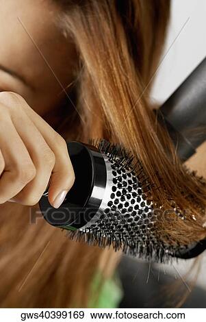Close-up of a woman drying her hair with a hair dryer View Large Photo Image Stock Photo - Close-up of a woman drying her hair with a hair dryer. Fotosearch