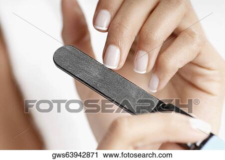 Close-up of a woman's hand filing her nails View Large Photo Image Stock Image - Close-up of a woman's hand filing her nails. Fotosearch