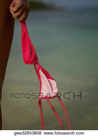 Stock Photo - Close-up of a woman's hand holding a bikini top. Fotosearch