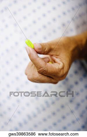 Close-up of a woman's hand holding a pill View Large Photo Image Stock Photograph - Close-up of a woman's hand holding a pill. Fotosearch