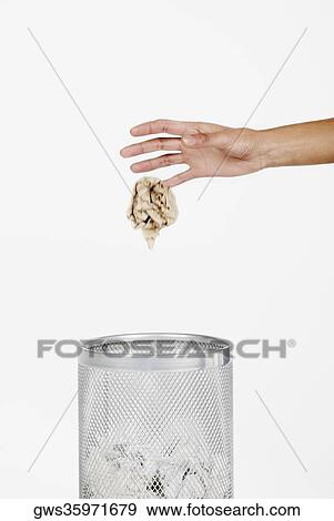 Close-up of a woman's hand throwing crumpled paper in a wastepaper basket View Large Photo Image Stock Photo - Close-up of a woman's hand throwing crumpled paper in a wastepaper basket. Fotosearch