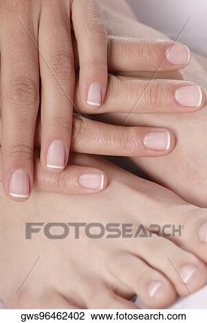 Stock Image - Close-up of a woman's hand touching her feet. Fotosearch